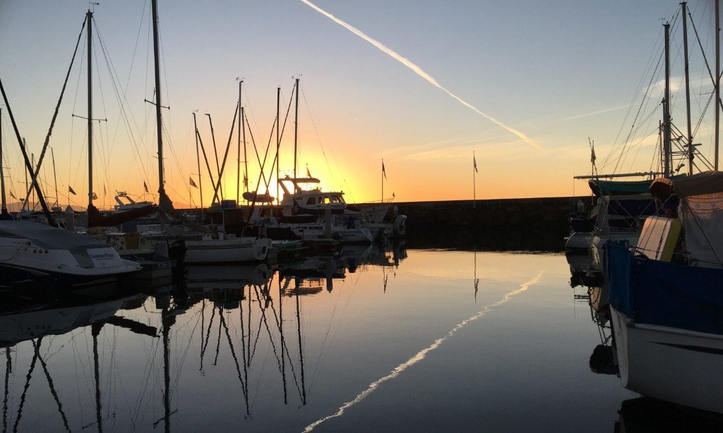Sunset over Santa Barbara Harbor, boats reflected in still water